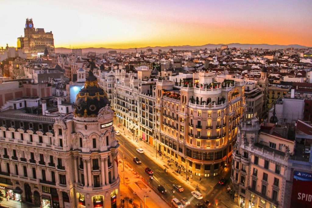 Fotografía aérea de vehículos que pasan entre edificios de gran altura.